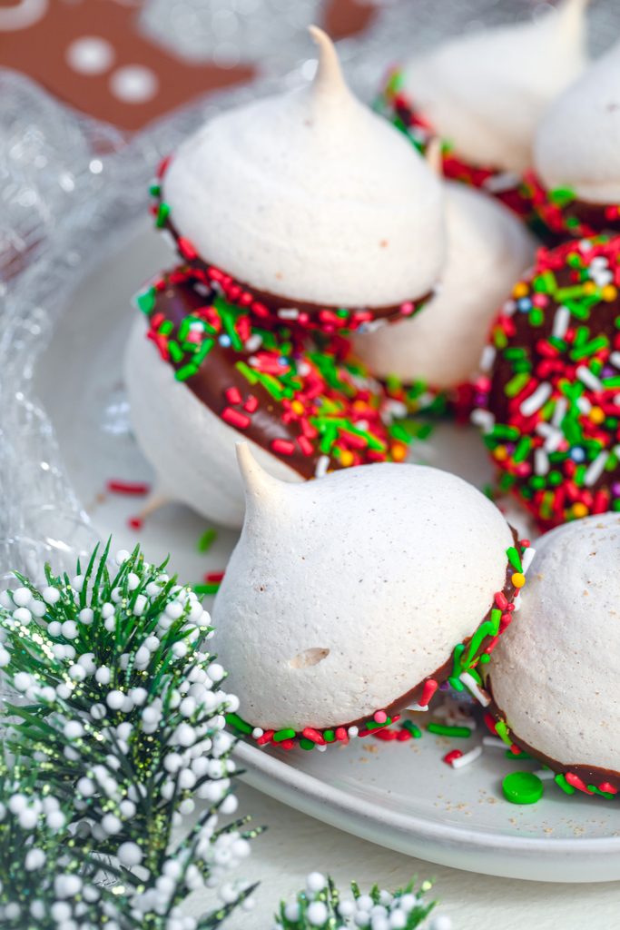 Orange Gingerbread Meringues -- Holiday meringues make the perfect addition to your holiday cookie platters! These melt-in-your-mouth Orange Gingerbread Meringues are packed with seasonal spices and dipped in dark chocolate | wearenotmartha.com