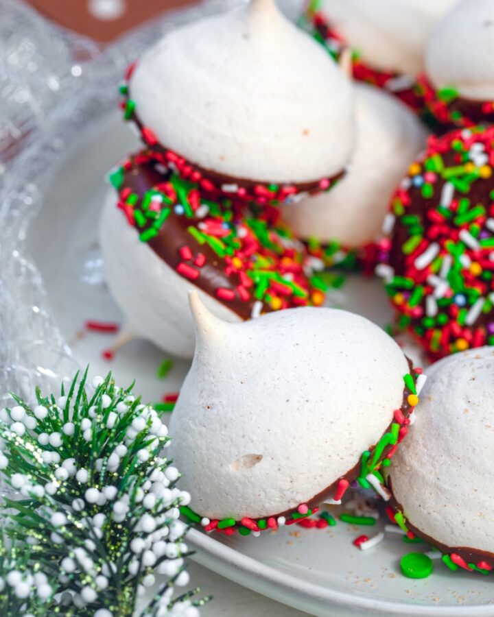 Orange Gingerbread Meringues -- Holiday meringues make the perfect addition to your holiday cookie platters! These melt-in-your-mouth Orange Gingerbread Meringues are packed with seasonal spices and dipped in dark chocolate | wearenotmartha.com