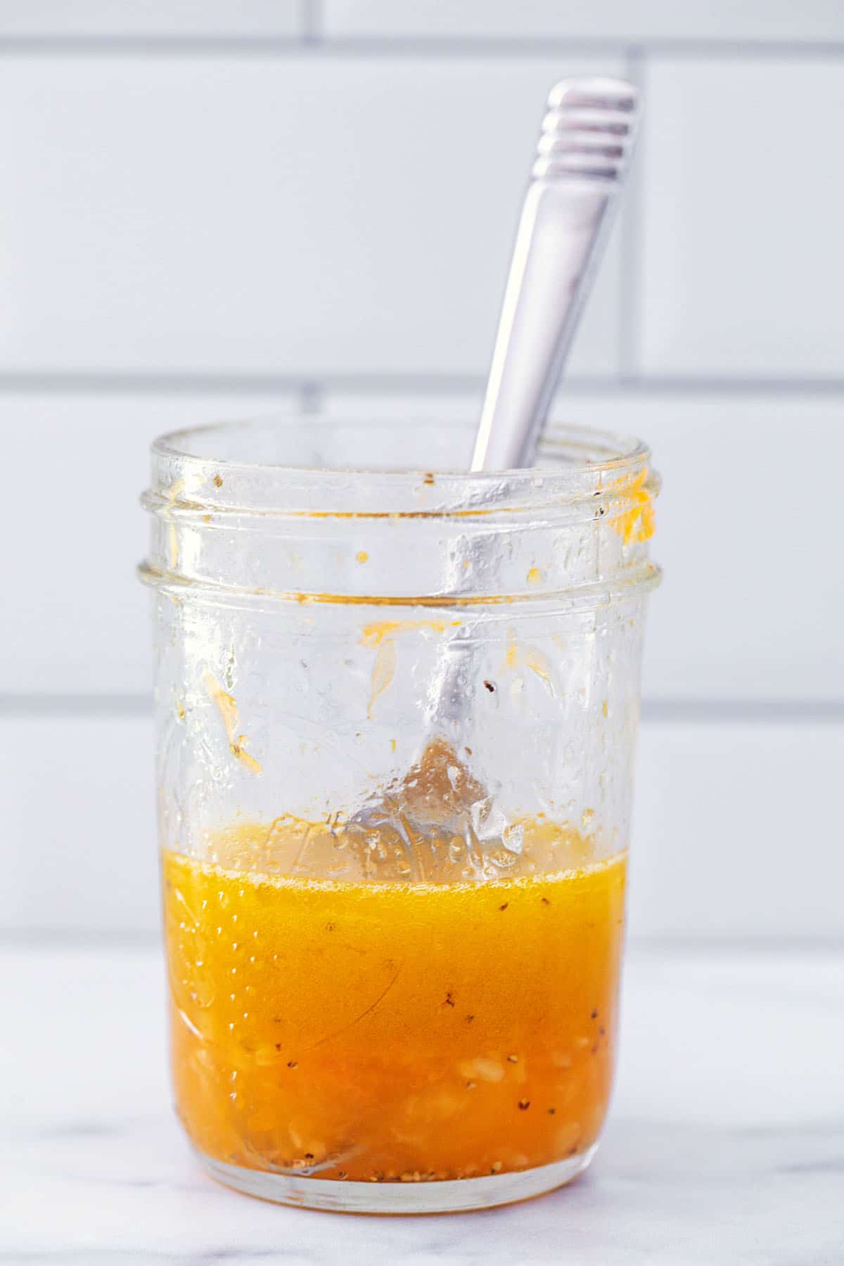 Homemade lemon garlic dressing in a small mason jar.