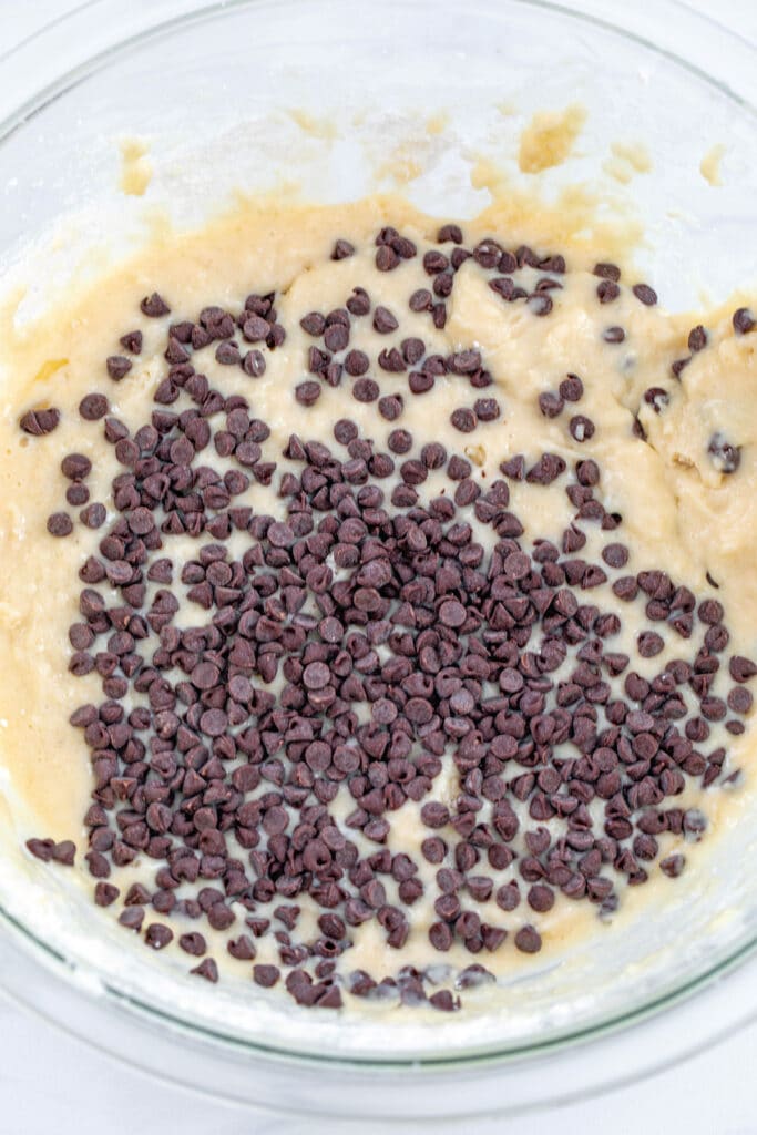Pancake mix donut batter with chocolate chips in mixing bowl.