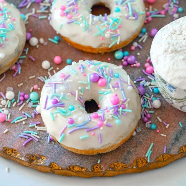 Close-up view of a pancake mix donut with vanilla icing and sprinkles.