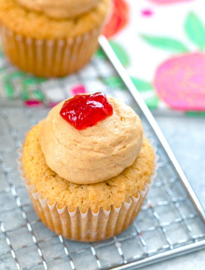 Peanut Butter and Jelly Cupcakes -- You'll feel like a kid again when you bite into one of these Peanut Butter and Jelly Cupcakes. The peanut butter cupcakes have a strawberry jelly filling, peanut butter frosting, and a dollop of jelly on top! | wearenotmartha.com