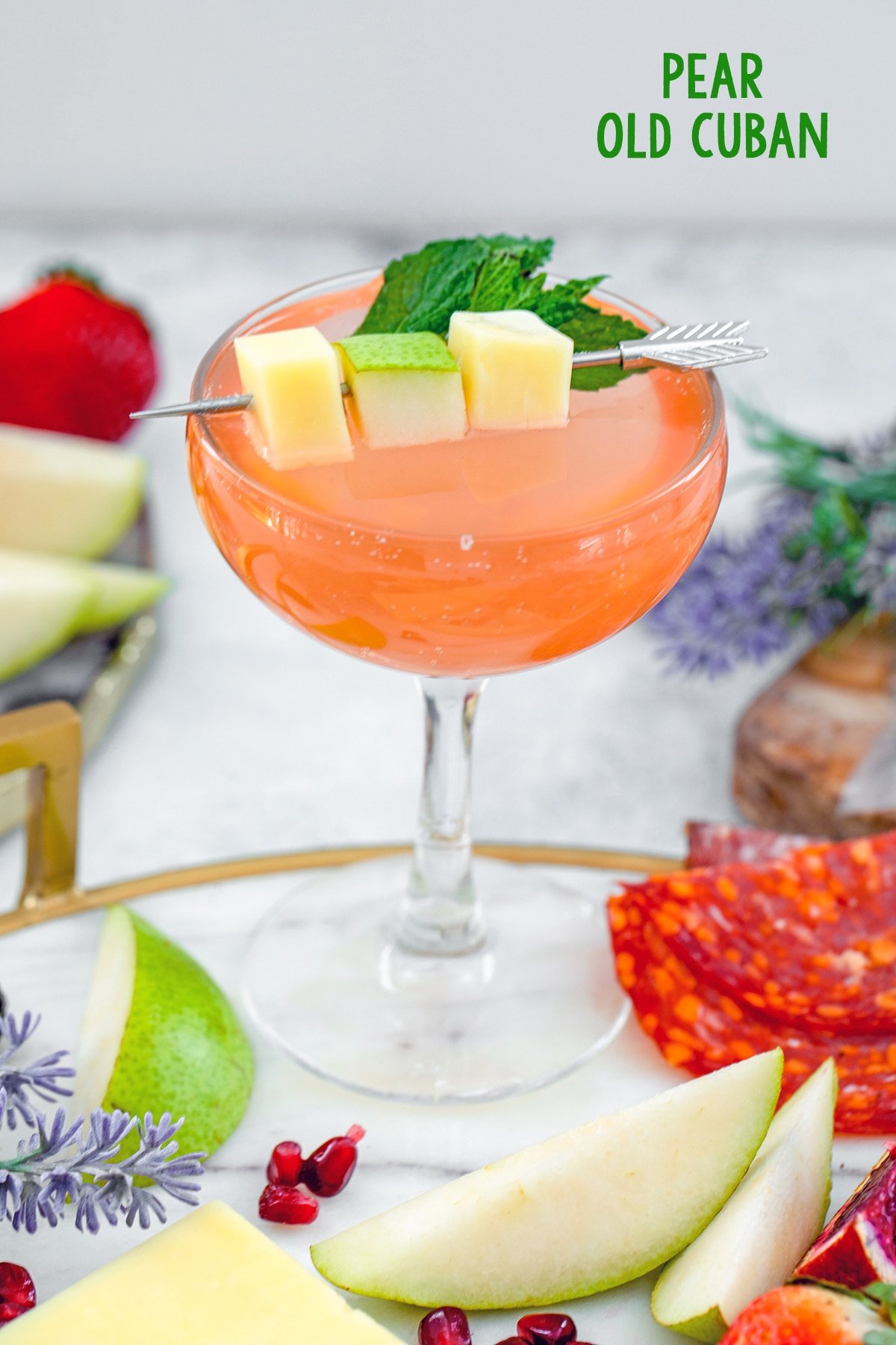 Head-on view of a pear old cuban cocktail with pear slices all around and recipe title at top.