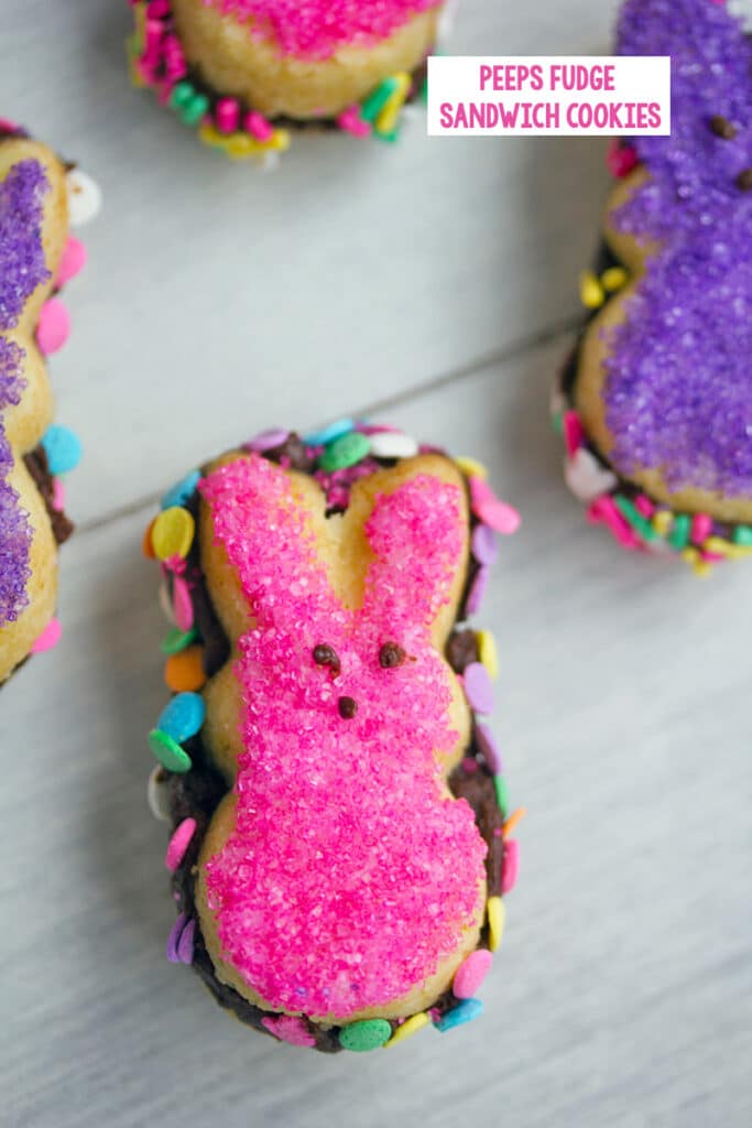 Overhead view of pink Peeps fudge sandwich cookie with more cookies in background and recipe title at top.