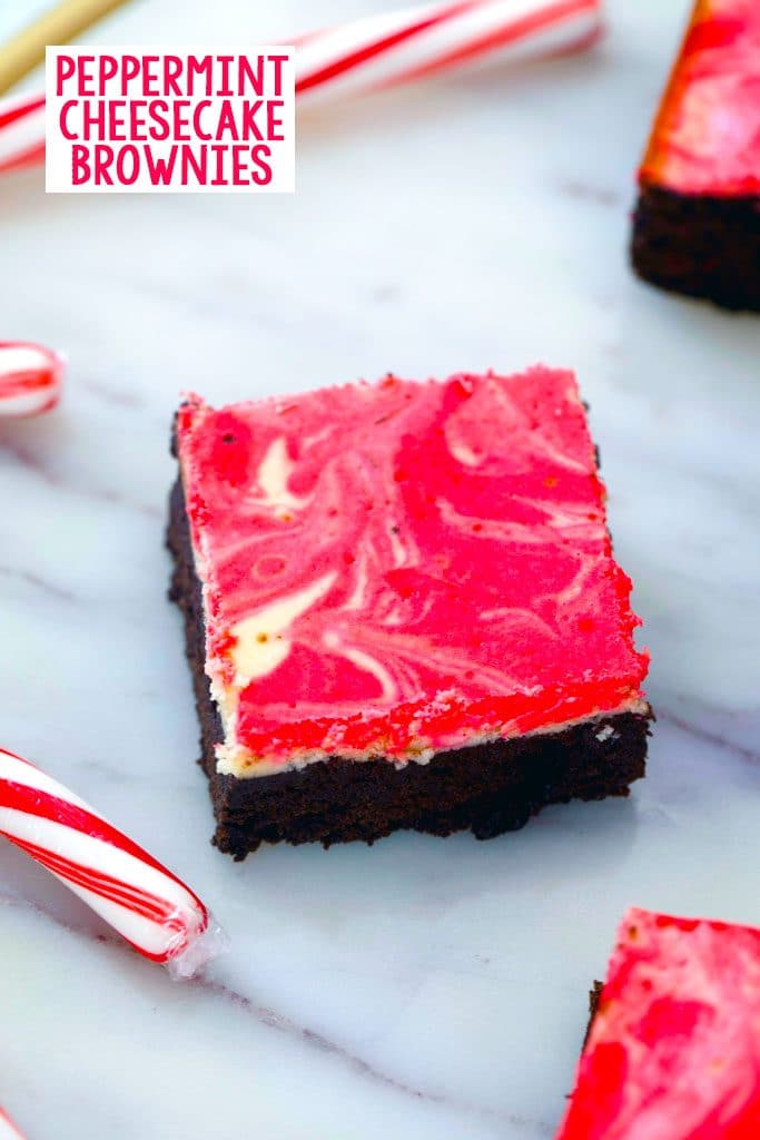 Overhead view of peppermint cheesecake brownie on a marble surface with candy canes in the background and recipe title at the top