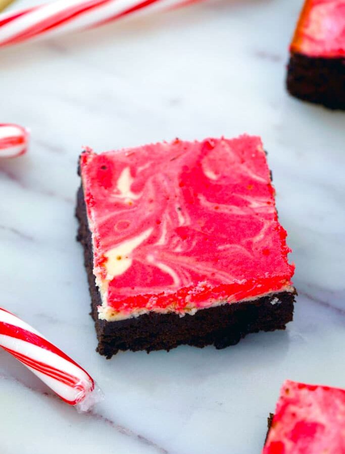 Peppermint Cheesecake Brownies -- These Peppermint Cheesecake Brownies are packed with festive peppermint flavor with a dreamy red and white swirl, making them the perfect holiday party dessert | wearenotmartha.com