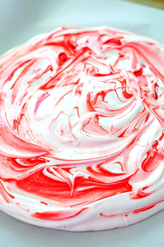 Overhead view of peppermint pavlova just out of oven with red swirl