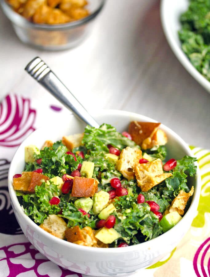 Pomegranate Avocado Kale Caesar Salad -- Caesar salads are nice, but they're even better when made with kale and avocado. This Pomegranate Avocado Kale Caesar Salad with parmesan croutons is the most delicious side or entree salad! | wearenotmartha.com