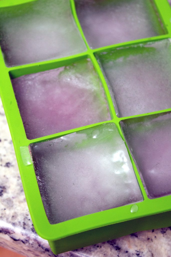 Large ice cube mold filled with pomegranate ice cubes