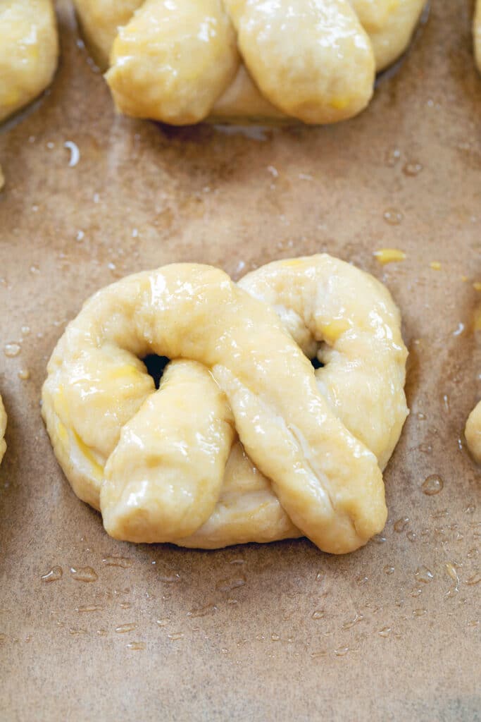Pumpkin beer pretzels formed on baking sheet after being dipped in baking soda water