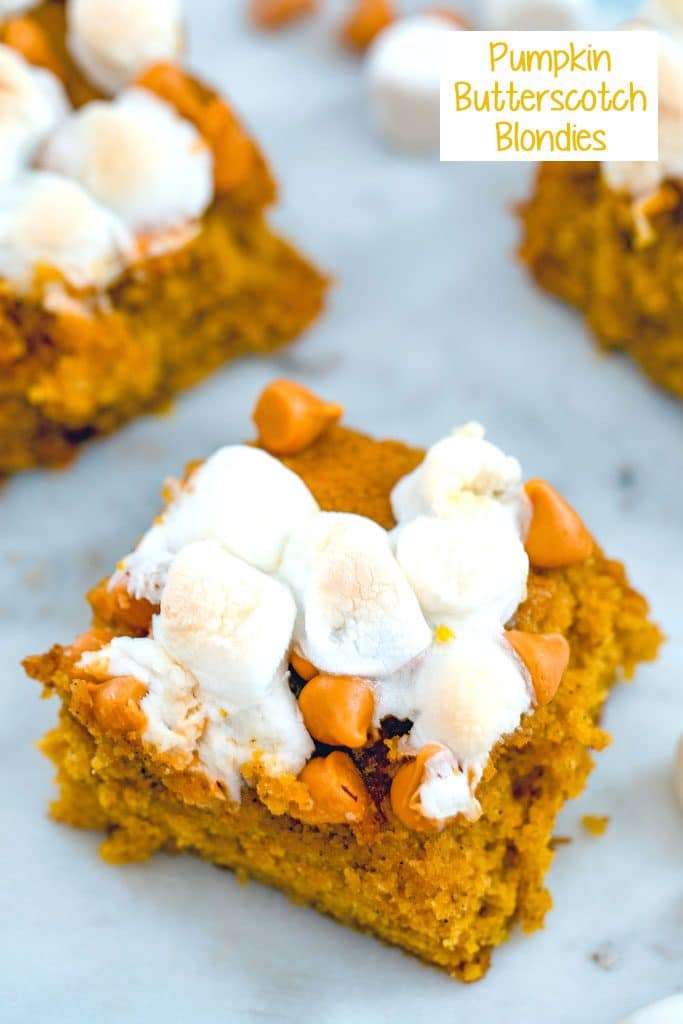 Overhead view of multiple pumpkin butterscotch blondies topped with marshmallows on a white surface with recipe title at top of image