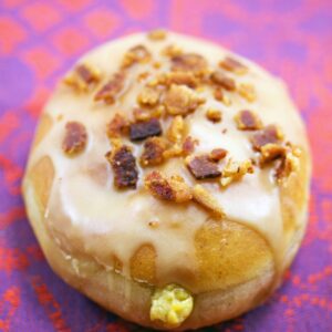 Pumpkin Doughnuts with Maple Bacon Frosting -- If you're going to make pumpkin doughnuts, you may as well go all out with these pumpkin doughnuts filled with pumpkin custard and topped with maple bacon frosting | wearenotmartha.com