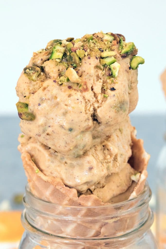 Close-up head-on view of pumpkin ice cream with pistachio swirl in a cone set in a mason jar