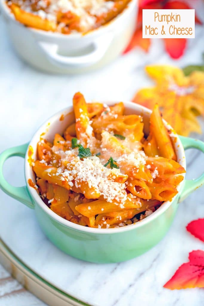 Overhead view of pumpkin mac and cheese in a green ramekin on a marble surface with fall leaves in the background and recipe title at the top