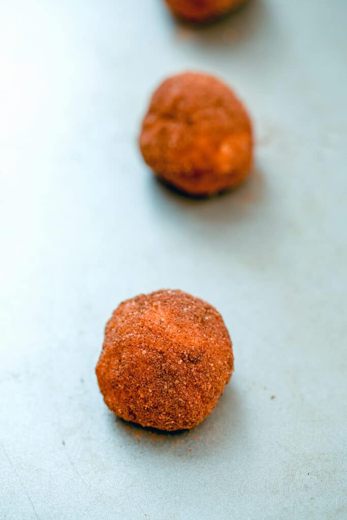 Cinnamon sugar coated pumpkin snickerdoodle dough balls on a baking sheet