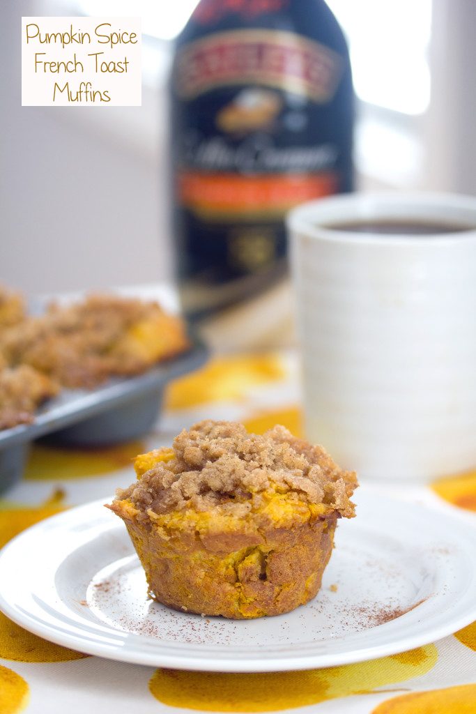 Head-on view of a pumpkin spice french toast muffin on a white plate with muffin tin, cup of coffee, and bottle of coffee creamer in background with recipe title at top