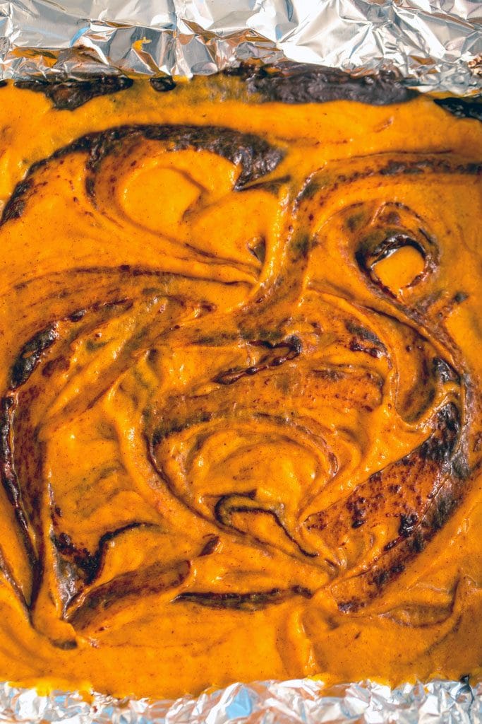 Overhead view of pumpkin and chocolate batters swirled together in a pan before going in the oven