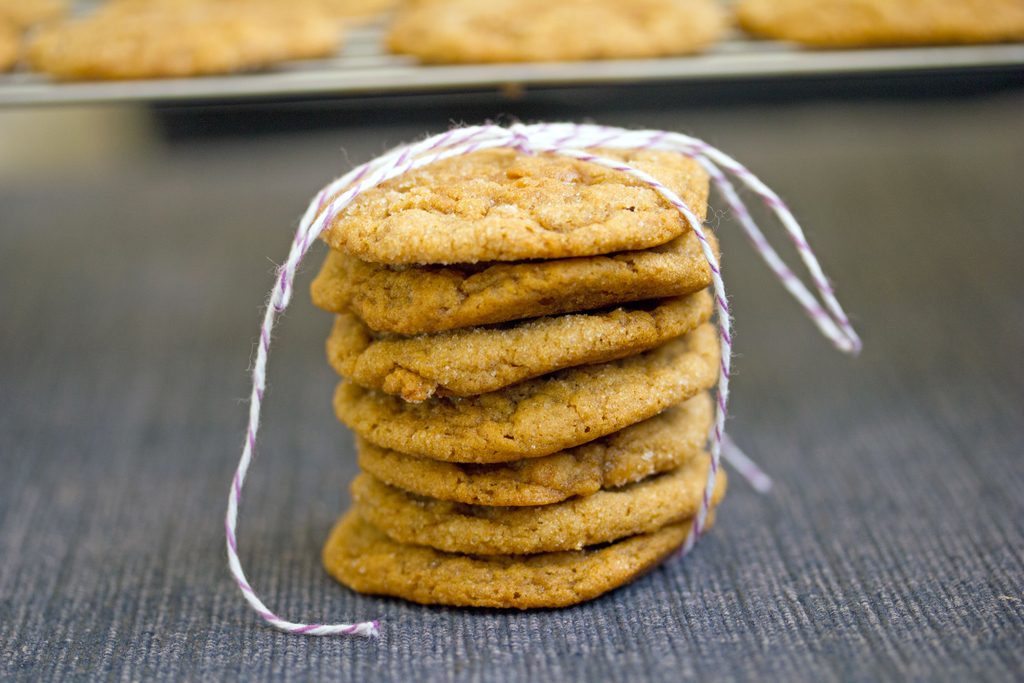 Landscape head-on closeup view of a stack of pumpkin toffee gingersnaps tied up with bakers twine