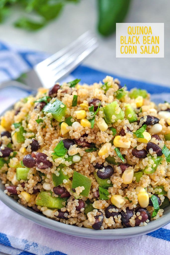Close-up of quinoa black bean corn salad on a colorful towel with a fork in the background and "Quinoa Black Bean Corn Salad" text at top