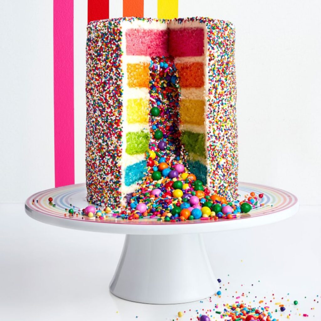 Rainbow explosion cake cut open with sprinkles coming out