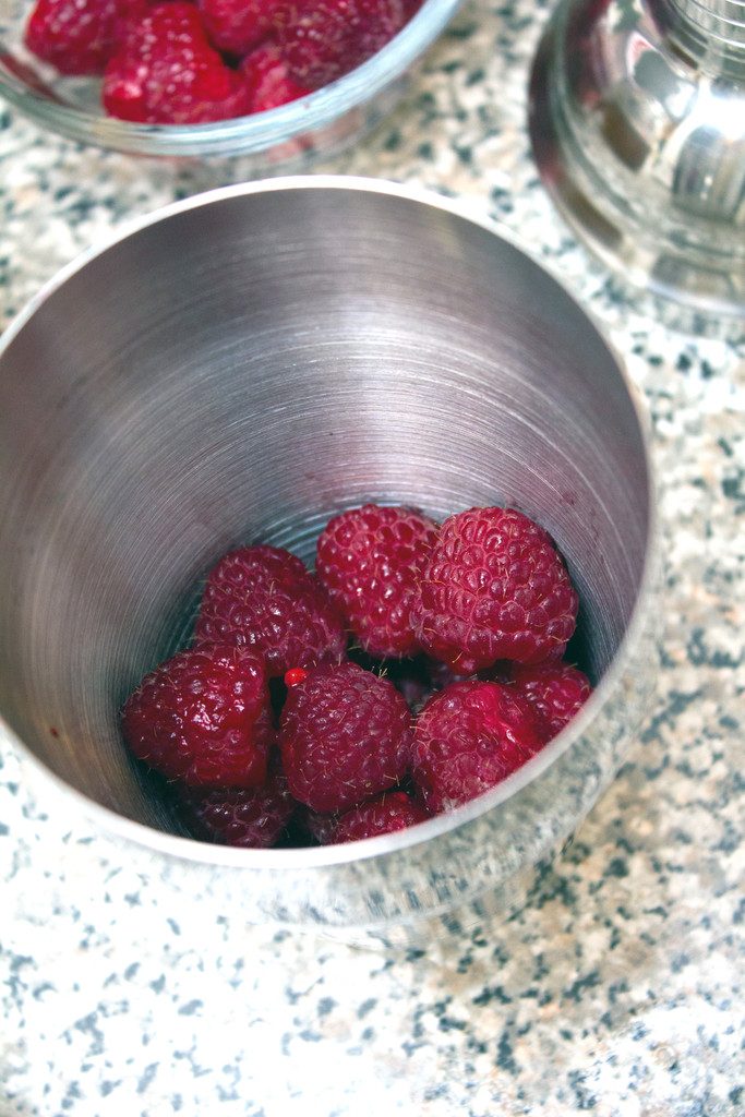 Overhead view of raspberries on the bottom of a cocktail shaker