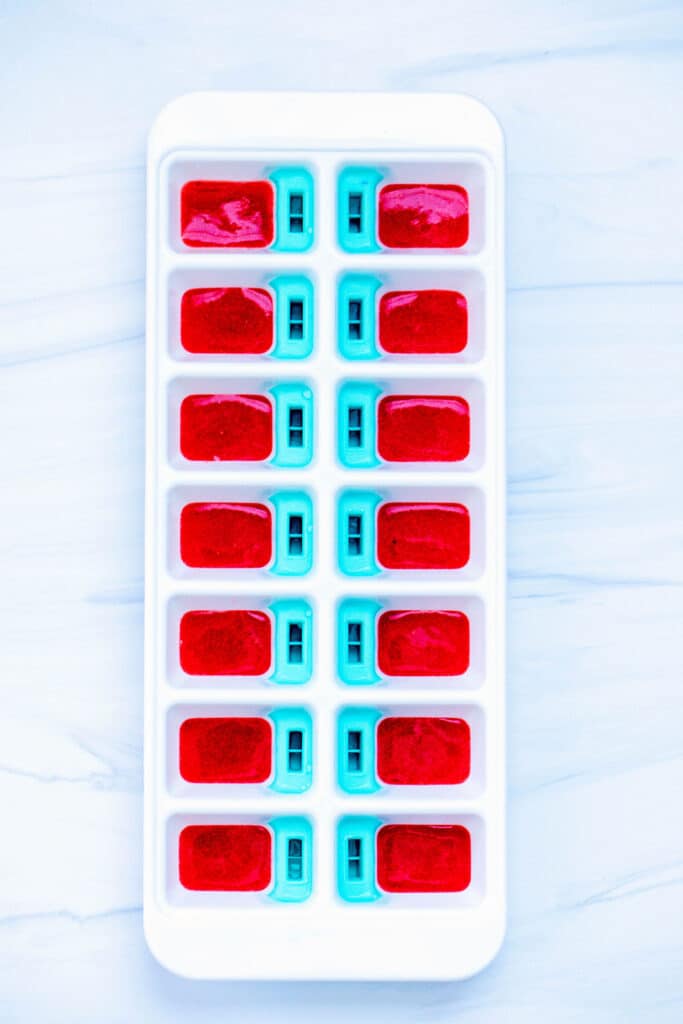 Red liquid layer poured into ice cube tray