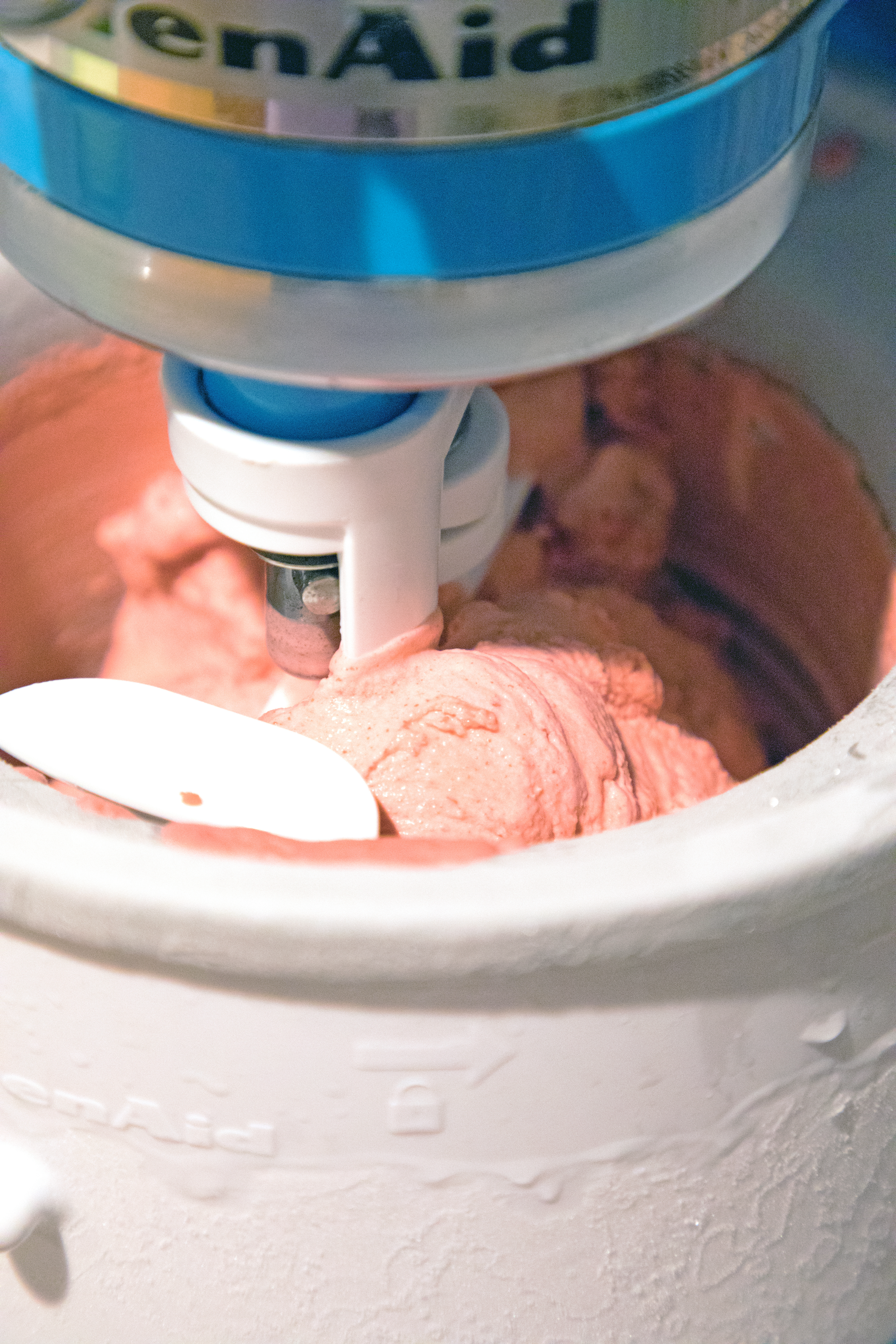 Red velvet ice cream churning in ice cream maker bowl.