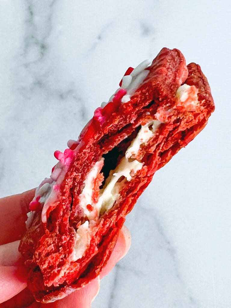 A red velvet Pop Tart with a bite taken out of it to show cream cheese filling.