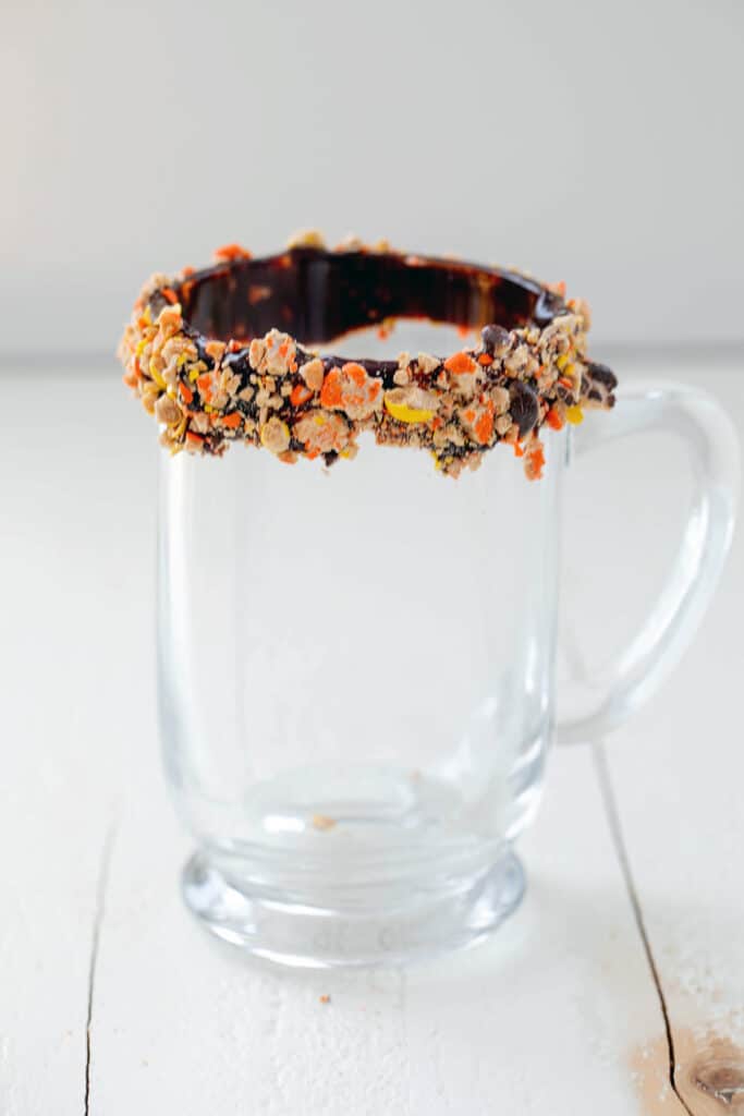 Hot drink mug with chocolate-coated rim covered in crushed Reese's Pieces