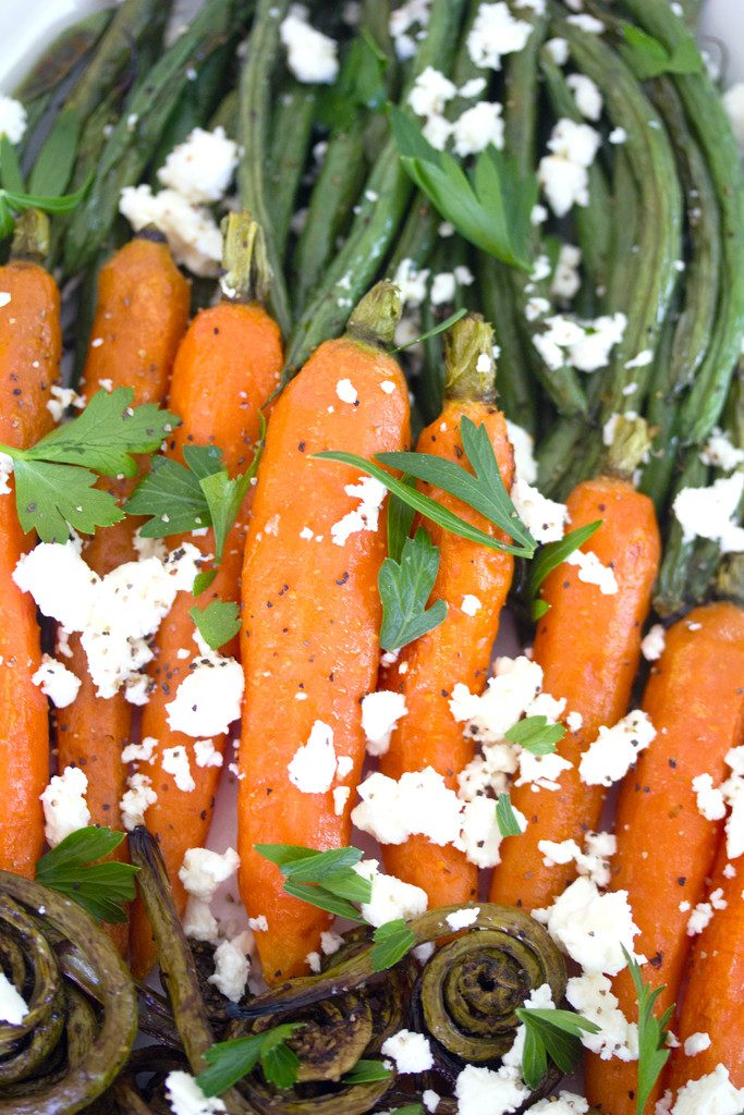 Closeup of roasted heirloom carrots with feta cheese and parsely