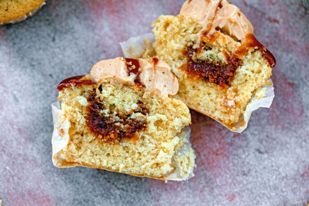 Overhead landscape view of salted caramel cupcake cut in half showing filling in center