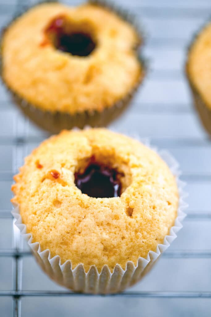 Overhead view of baked cupcakes with center cored out and caramel filling in them