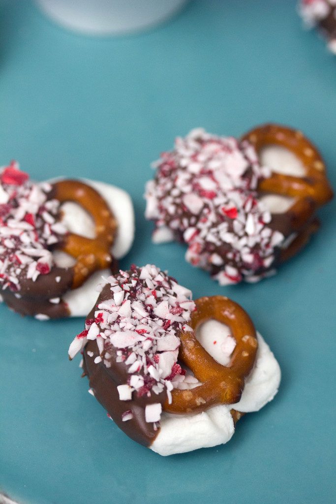 Overhead view of three hot chocolate peppermint pretzel bites on a teal platter