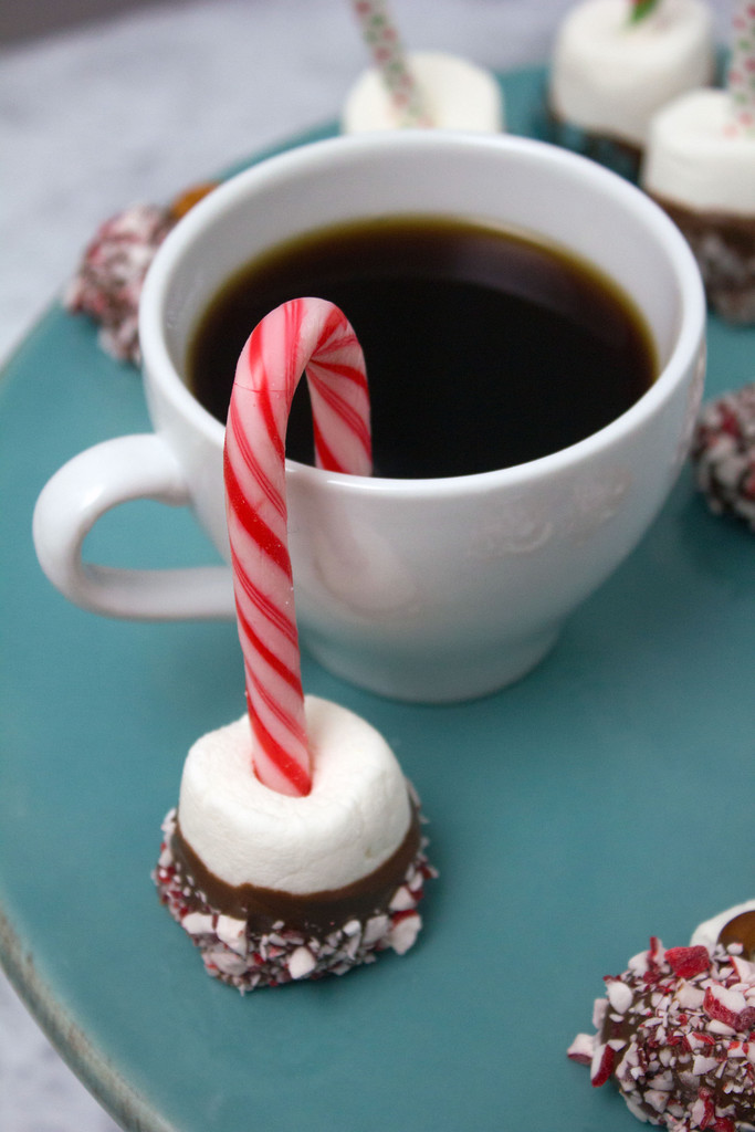 Mug of coffee with chocolate dipped marshmallow with mini candy cane dipped in it