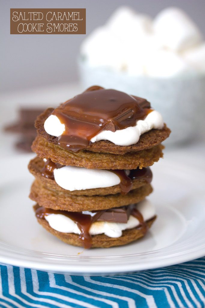 Head-on view of salted caramel cookie s'mores stacked on top of each other with bowl of marshmallows in background and recipe title at top
