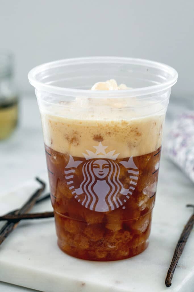 Shaken espresso poured into Starbucks cup with ice.