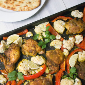 Sheet Pan Curry Chicken Thighs -- a sheet pan dinner with cauliflower and peppers, served with naan and yogurt sauce! | wearenotmartha.com