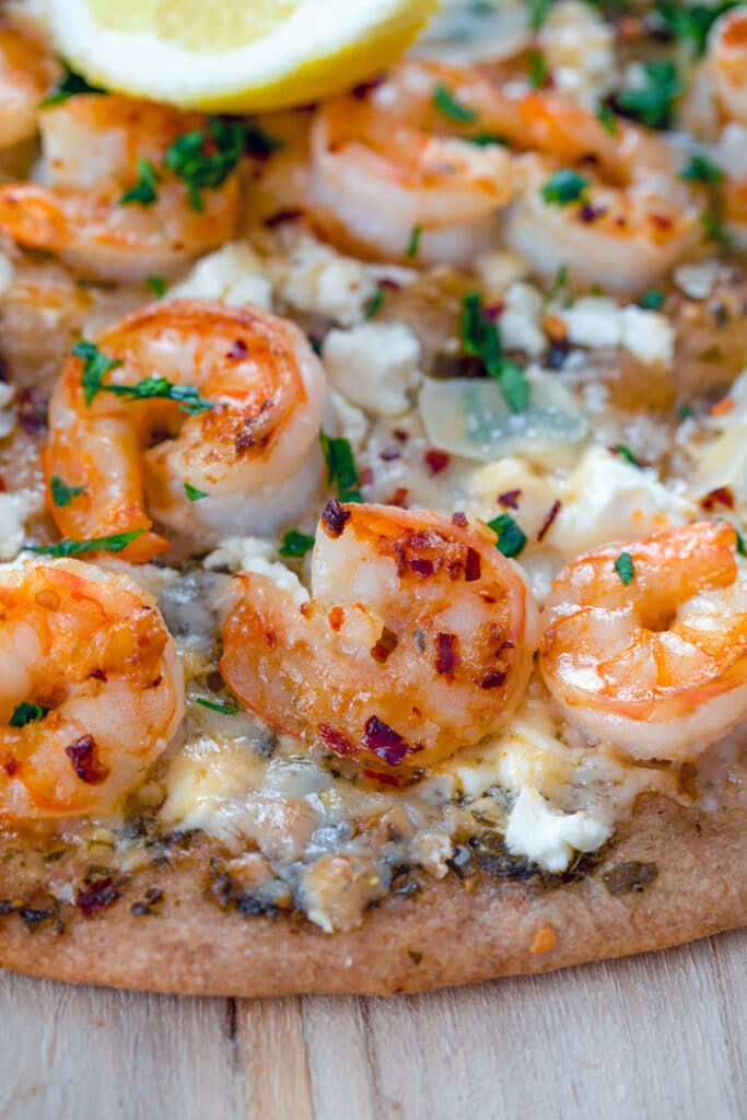 Closeup of shrimp on shrimp scampi pizza.