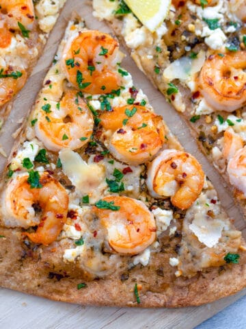 Overhead closeup view of slice of shrimp scampi pizza