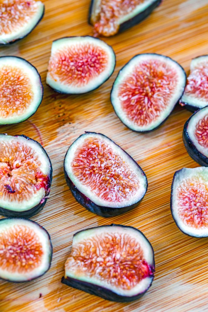 Overhead view of sliced figs on a cutting board