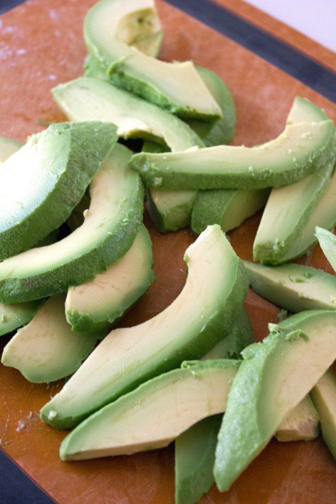 Overhead view of sliced avocados on a cutting board