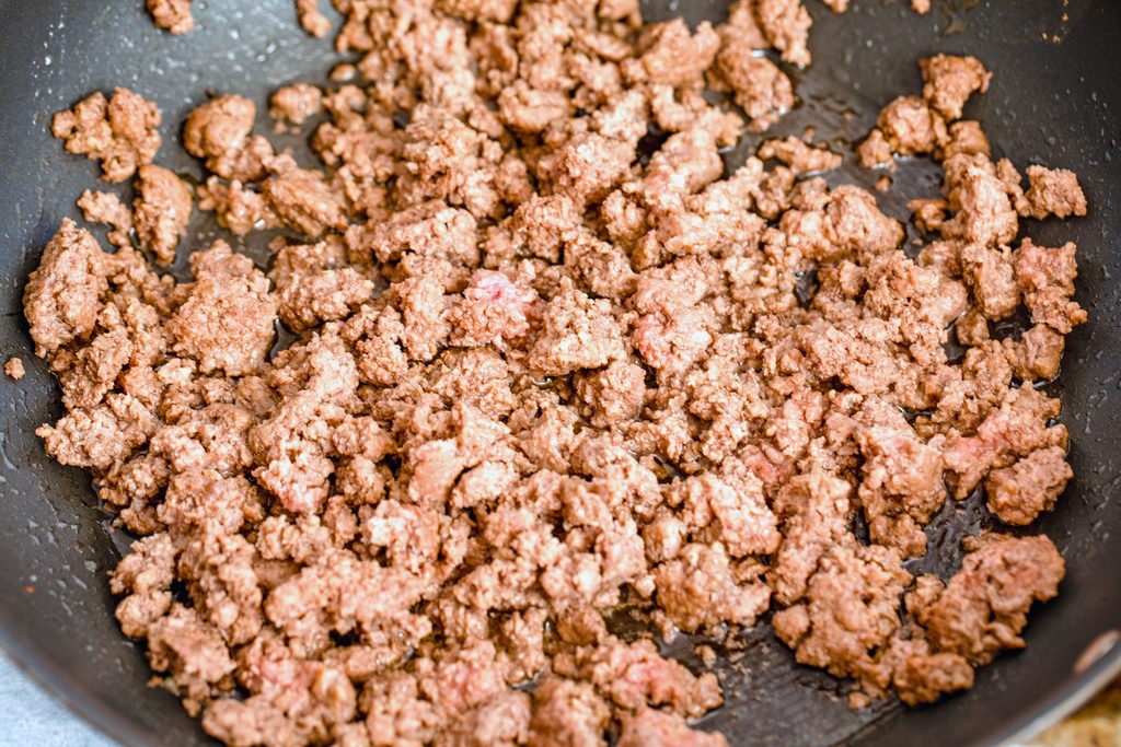 Overhead view of ground beef browning in skillet