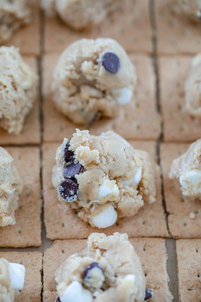 Rows of graham cracker squares with scoops of chocolate chip and marshmallow cookie dough on top