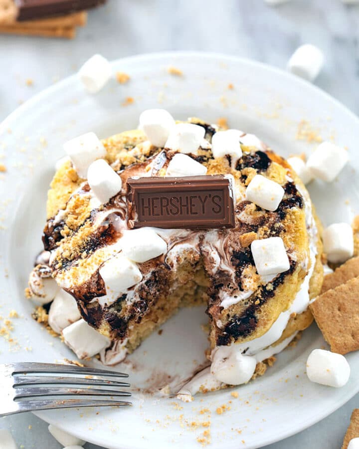 S'mores Pancakes -- Whether you need a little Sunday brunch indulgence or are taking breakfast for dinner to new levels, these S'mores Pancakes packed with graham cracker flavor, homemade marshmallow fluff, and chocolate sauce are sure to make your whole family happy | wearenotmartha.com #smores #pancakes #fluff #marshmallow #brunch
