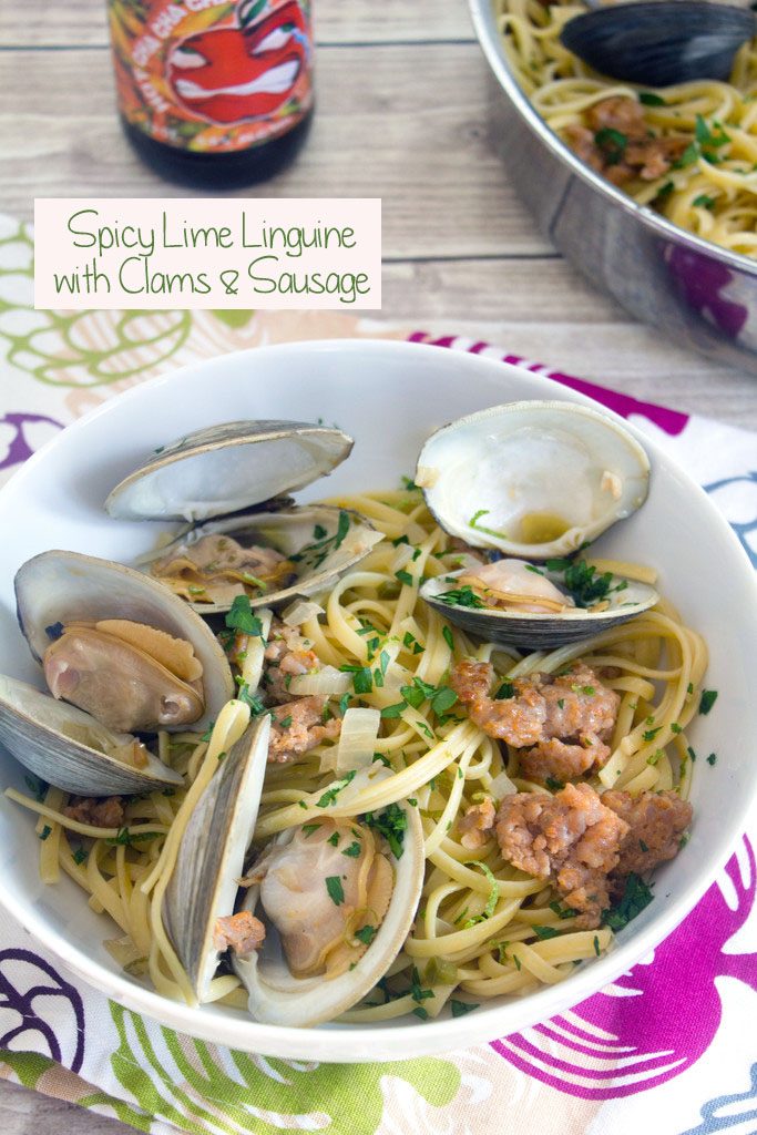 Overhead view of a big bowl of spicy lime linguine with clams and sausage with a hard cider in the background and recipe title at top