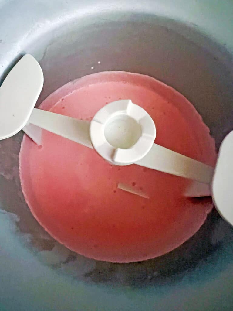 Starburst milk mixture poured into ice cream maker bowl.