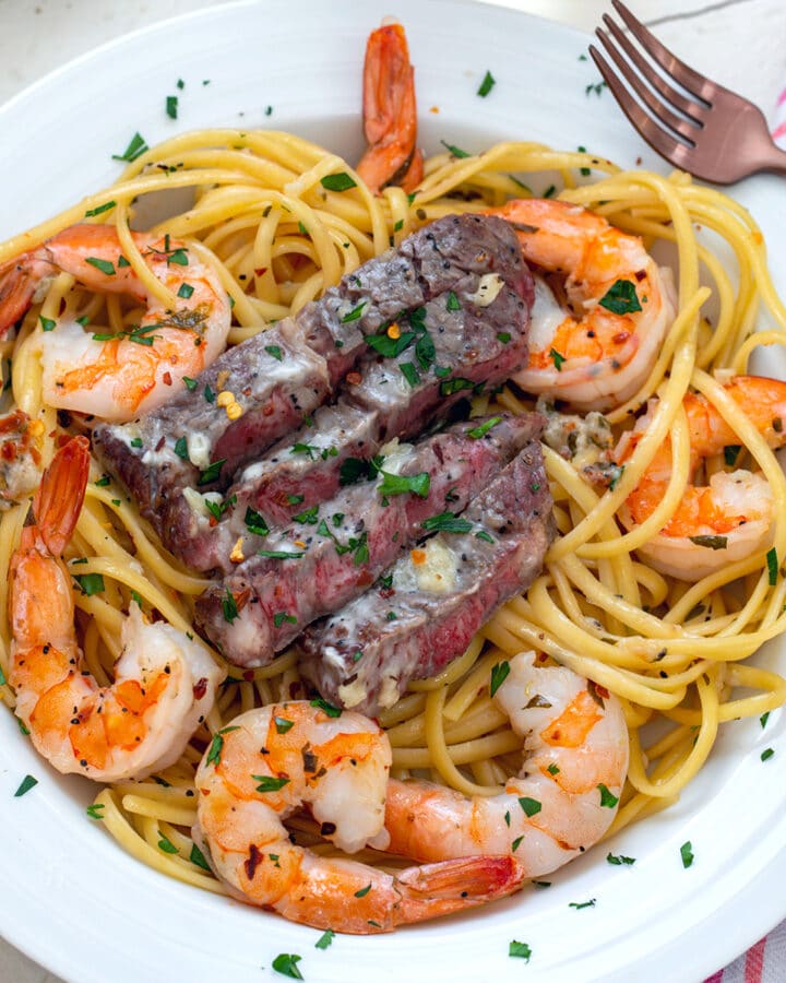 Close-up view of steak and shrimp scampi in a white bowl