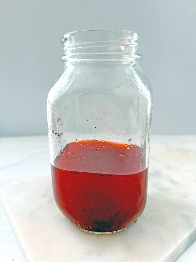 Strawberry acai refresher base in large mason jar.