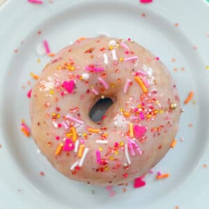 Strawberry Frosted Doughnuts -- If you're looking for a doughnut that's a little bit healthier, try these baked Strawberry Frosted Doughnuts! They're made with vanilla Greek yogurt and are a whole lot easier to make at home than fried doughnuts! | wearenotmartha.com