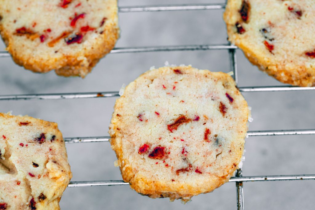 Overhead view of baked strawberry cookies cooling on baking rack